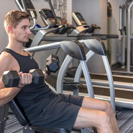 Meriton Suites North Ryde Sydney Exterior foto A man using a dumbbell to exercise