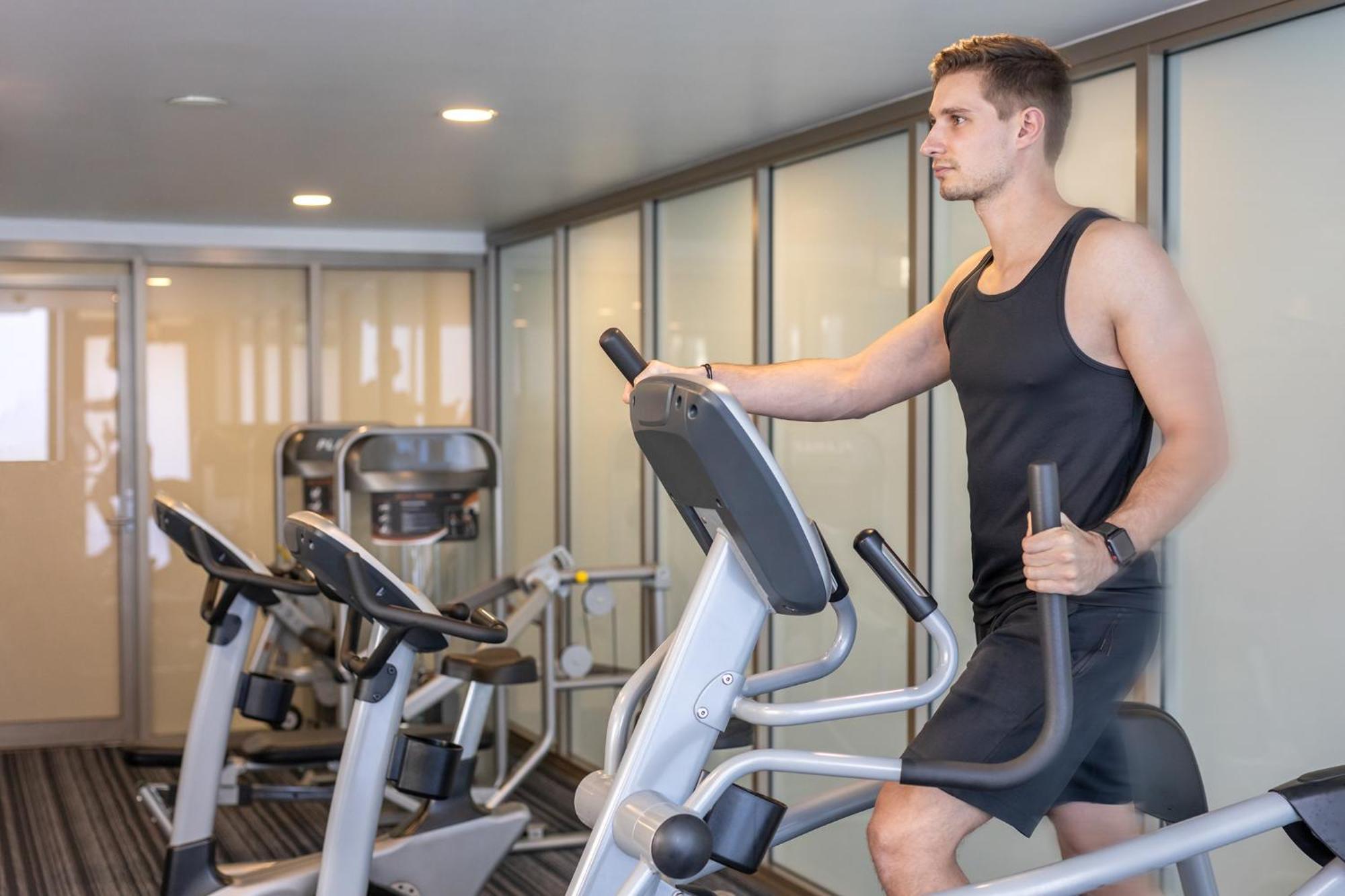 Meriton Suites North Ryde Sydney Exterior foto A man using an elliptical trainer